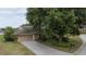 Exterior of home with driveway, large tree, and well-maintained landscaping at 6047 Shore Line Dr, Orlando, FL 32819