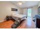 Well-lit main bedroom with hardwood floors, ceiling fan, and sliding glass doors to the backyard at 6047 Shore Line Dr, Orlando, FL 32819