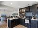 Well-lit kitchen with black cabinets, open shelving, and stainless steel appliances at 631 Warrenton Rd, Winter Park, FL 32792