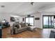 Open-concept living room featuring a modern sofa, hardwood floors, and lots of natural light at 631 Warrenton Rd, Winter Park, FL 32792