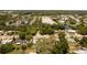 Aerial view showcases the property near a lake, business district, and surrounded by mature trees at 826 Cherokee Cir, Sanford, FL 32773