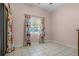 Well-lit bedroom with ceramic tile flooring, a large window, and floral curtains at 826 Cherokee Cir, Sanford, FL 32773