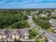 Wide aerial view showcasing residential area, adjacent main road and tree lined horizon at 8704 Knightsbridge Ct # B, Kissimmee, FL 34747