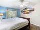 This bedroom offers a ceiling fan, a large bed and sliding door access to the outdoors at 8704 Knightsbridge Ct # B, Kissimmee, FL 34747