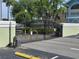 View of the entrance gate to the property with landscaping and a security gate at 8704 Knightsbridge Ct # B, Kissimmee, FL 34747