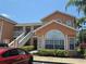 Charming multi-story condo featuring orange siding, white trim, and well-maintained landscaping at 8704 Knightsbridge Ct # B, Kissimmee, FL 34747