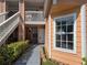 Inviting condo entrance with well-maintained landscaping, exterior staircase, and sunlit walkway at 8704 Knightsbridge Ct # B, Kissimmee, FL 34747