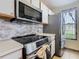 Modern kitchen featuring stainless steel appliances, tile backsplash, and a stainless steel refrigerator at 8704 Knightsbridge Ct # B, Kissimmee, FL 34747