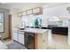 Kitchen featuring modern white cabinets, stainless steel dishwasher, and a view of the living room at 8704 Knightsbridge Ct # B, Kissimmee, FL 34747