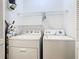Efficient laundry room with washer, dryer, ironing board, and overhead storage at 8704 Knightsbridge Ct # B, Kissimmee, FL 34747