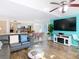 Bright living room featuring hardwood floors, ceiling fan and turquoise accent wall with entertainment center at 8704 Knightsbridge Ct # B, Kissimmee, FL 34747