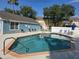 Community pool with ample seating, pool house, and well-maintained fencing at 8704 Knightsbridge Ct # B, Kissimmee, FL 34747