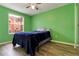 Cozy bedroom with wood floor, window, closet with mirror, and green paint at 8719 Rockingham Ter # B, Kissimmee, FL 34747
