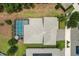 An aerial view of a home with a screened-in pool and well-manicured landscaping at 8811 Bally Neal Loop, Davenport, FL 33896