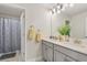 Well-lit bathroom featuring double sinks, a large mirror, and a shower at 8811 Bally Neal Loop, Davenport, FL 33896