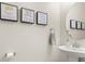 Charming half-bath featuring elegant decor and a decorative round mirror at 8811 Bally Neal Loop, Davenport, FL 33896