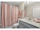 Bathroom featuring a peach shower curtain, modern sink, and neutral color palette at 8811 Bally Neal Loop, Davenport, FL 33896