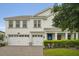 Two-story home featuring a 2 car garage, blue front door, and gray brick driveway at 8811 Bally Neal Loop, Davenport, FL 33896
