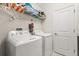 Well-equipped laundry room with washer, dryer, and shelving for storage at 8811 Bally Neal Loop, Davenport, FL 33896