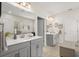 Modern bathroom with double sinks, gray cabinets, and a walk-in shower, offering a clean and functional design at 8811 Bally Neal Loop, Davenport, FL 33896