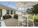 Covered outdoor patio features white table, barstools, outdoor grill and brick pavers at 8811 Bally Neal Loop, Davenport, FL 33896