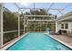 A screened in pool with lounge chairs and view of trees at 8811 Bally Neal Loop, Davenport, FL 33896