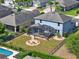 Aerial shot of home with screened patio, firepit, lush lawn and pool at 987 Nathan Ridge Rd, Clermont, FL 34715