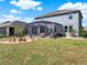 Fenced backyard with a screened patio and a cozy fire pit area at 987 Nathan Ridge Rd, Clermont, FL 34715
