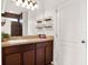 Bathroom featuring a wood vanity, granite countertop, decor shelving, and a tiled shower with glass door at 987 Nathan Ridge Rd, Clermont, FL 34715