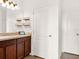 Bathroom with a wood vanity, granite countertop, decor shelving, and a tiled floor at 987 Nathan Ridge Rd, Clermont, FL 34715