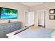 Bedroom with a queen bed, blue bedding, and a blue dresser with a television; doorways visible at 987 Nathan Ridge Rd, Clermont, FL 34715
