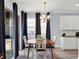 Cozy dining area featuring a modern chandelier, dark curtains, and sliding glass doors for natural light at 987 Nathan Ridge Rd, Clermont, FL 34715