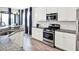 Modern kitchen with stainless steel appliances, granite countertops, and white cabinets, illuminated by natural light at 987 Nathan Ridge Rd, Clermont, FL 34715