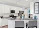 Well-lit kitchen featuring white cabinetry, stainless steel appliances, and a stylish breakfast bar with counter seating at 987 Nathan Ridge Rd, Clermont, FL 34715