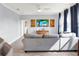 Bright living room featuring a gray sectional, wood-look tile, a ceiling fan, and a wall-mounted television at 987 Nathan Ridge Rd, Clermont, FL 34715