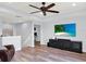 Comfortable living room features wood floors, a ceiling fan, and a media center at 987 Nathan Ridge Rd, Clermont, FL 34715
