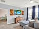 Living room with gray sectional and ottoman, wood-look floors, coastal-themed TV display, and dark blue curtains at 987 Nathan Ridge Rd, Clermont, FL 34715