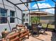 Screened-in patio featuring comfortable seating and a dining area with a neutral umbrella at 987 Nathan Ridge Rd, Clermont, FL 34715
