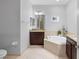 Serene bathroom showcasing a soaking tub, granite countertops, and modern fixtures in a neutral palette at 10430 Belfry Cir, Orlando, FL 32832