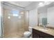 Bright bathroom features a glass shower and vanity with granite countertops and dark cabinets at 10430 Belfry Cir, Orlando, FL 32832