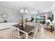 Open-concept dining area with a wood table, white chairs, and view of the living room and patio at 10430 Belfry Cir, Orlando, FL 32832