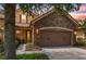 Charming home featuring a stone facade, a two-car garage, and a beautifully landscaped front yard at 10430 Belfry Cir, Orlando, FL 32832