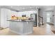 Bright kitchen boasts white cabinetry, stainless steel appliances, and a granite-topped island with tile floors at 10430 Belfry Cir, Orlando, FL 32832