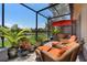 View of the screened in patio with wicker patio furniture overlooking the lake at 10430 Belfry Cir, Orlando, FL 32832