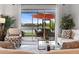 A view from the Living Room looking out on an outdoor patio with seating and a large orange umbrella at 10430 Belfry Cir, Orlando, FL 32832
