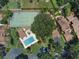 Aerial view of a community featuring a pool, tennis court, lush landscaping, and charming residential buildings at 105 Oaks Ct, Sanford, FL 32771