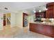 Spacious kitchen with stainless steel refrigerator, granite countertops and light tile flooring at 105 Oaks Ct, Sanford, FL 32771