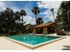 Outdoor pool with a pool house in a well-maintained common area with chairs and palm trees at 105 Oaks Ct, Sanford, FL 32771