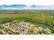 Beautiful aerial view of a community nestled among lush trees next to a large pond, with a view of the city at 1222 Golden Canna Ln, Celebration, FL 34747