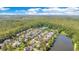 Beautiful aerial view of a community nestled among lush trees next to a large pond, with a view of the city at 1222 Golden Canna Ln, Celebration, FL 34747